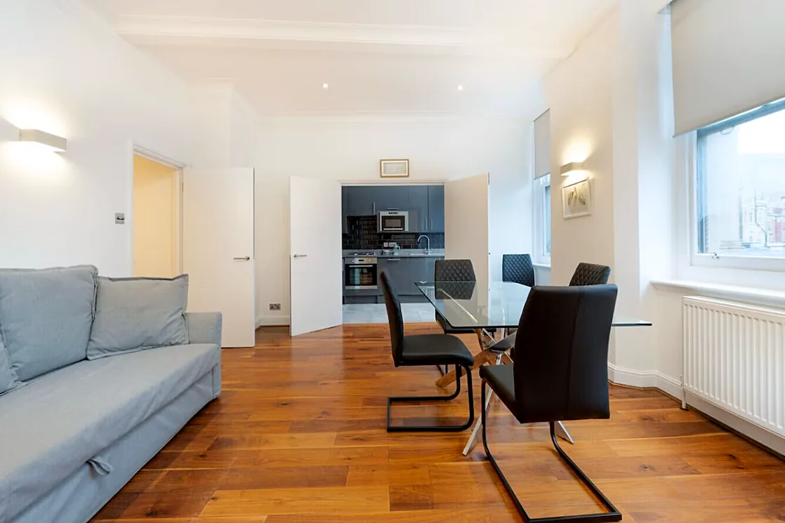Living room with sofa and dining table, kitchen beyond