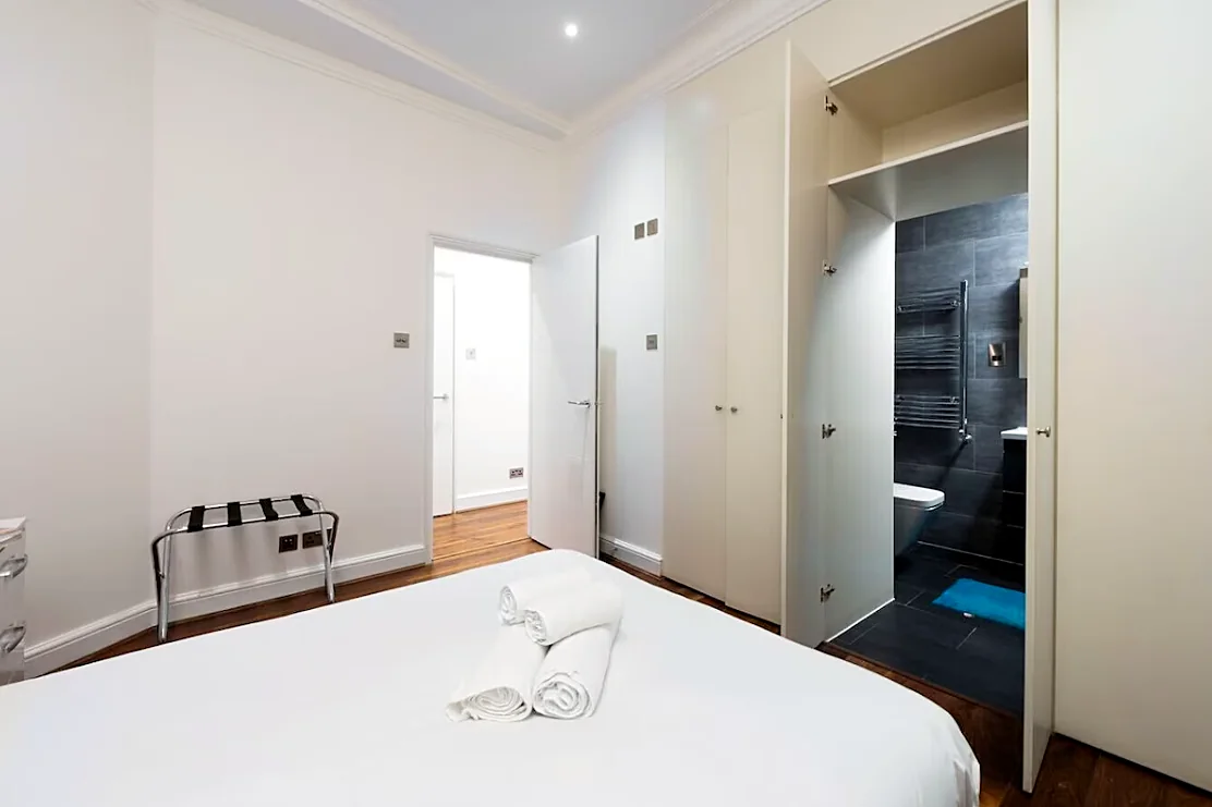 Bedroom with built-in wardrobes, bathroom beyond