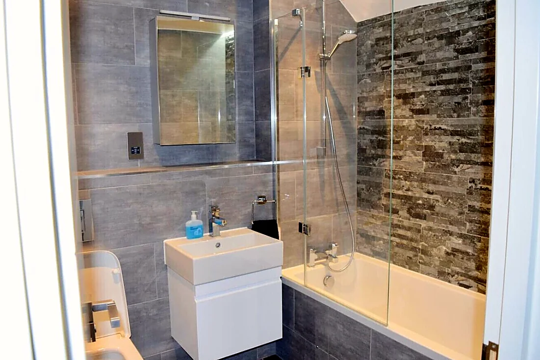 Bathroom with bath and shower screen