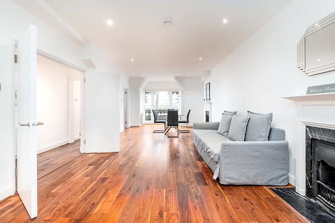 Apartment 4: Open-plan living room with walnut floors and fireplace